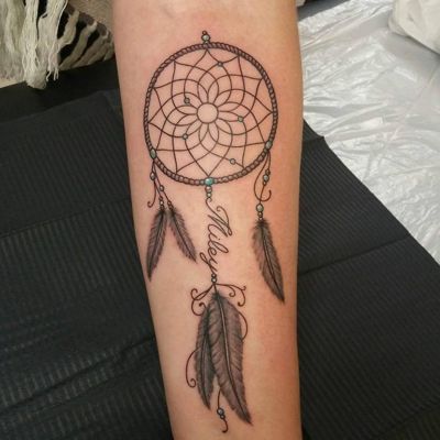  Tatouage attrape rêve avec un des files en écritures sur le bras